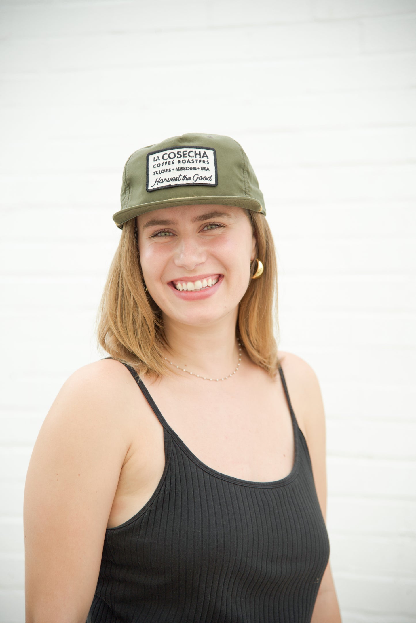 Woman wearing a green cap with text on a white background