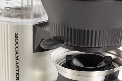 Close-up of a Moccamaster coffee maker with a focus on the brewing mechanism.