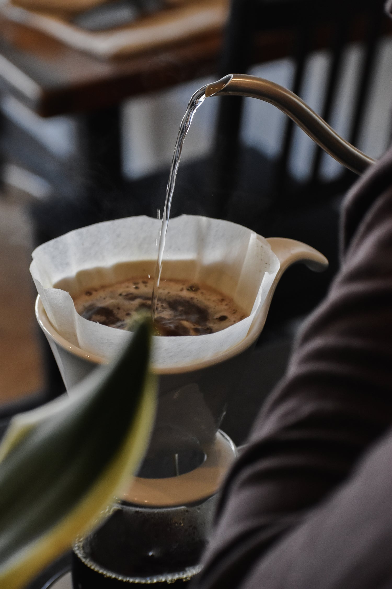 Coffee being poured into a filter with a blurred background