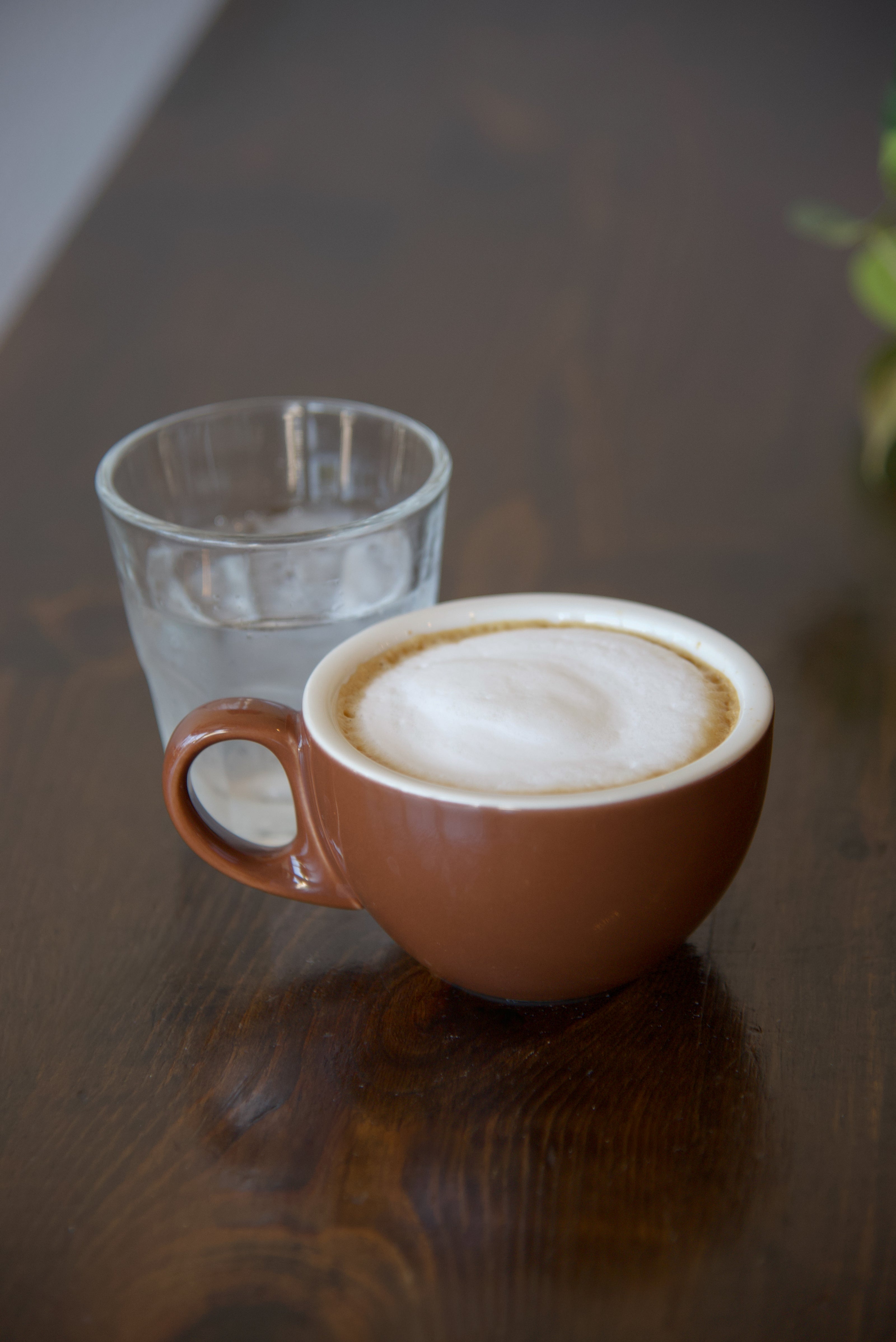 Cappuccino for here in a brown mug