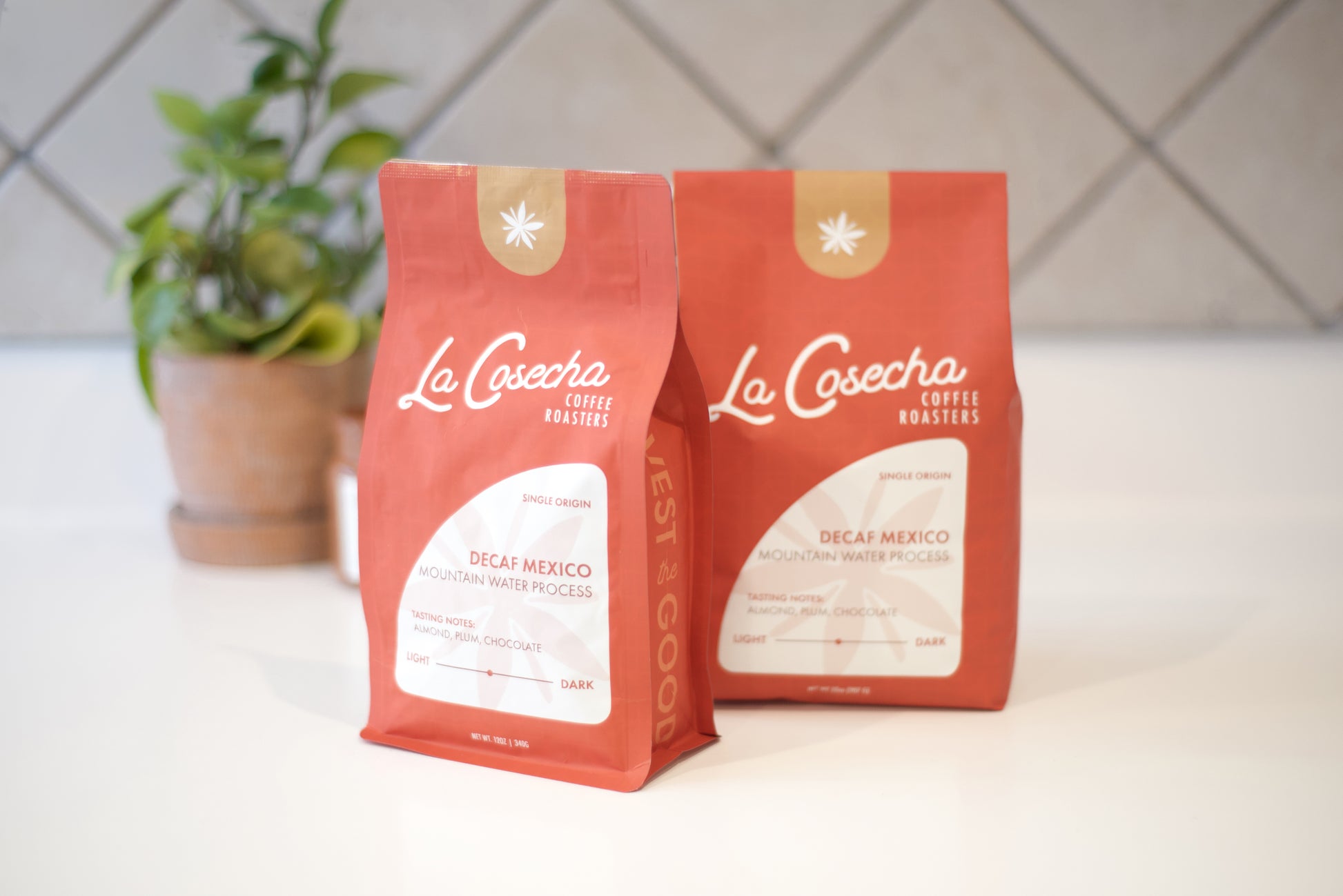 Two orange coffee bags with 'La Cosecha' branding on a white surface.