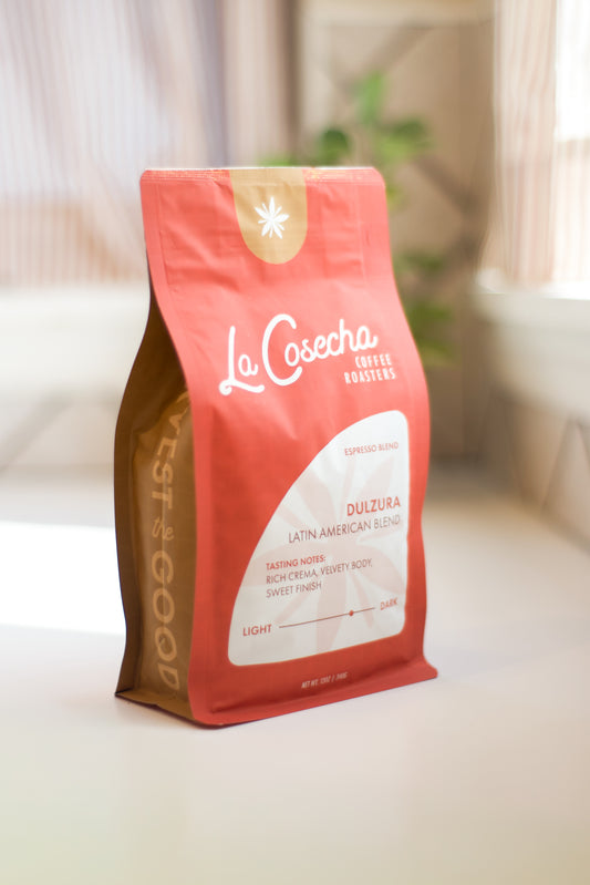 Orange coffee bag with 'La Cosecha' branding on a light surface.