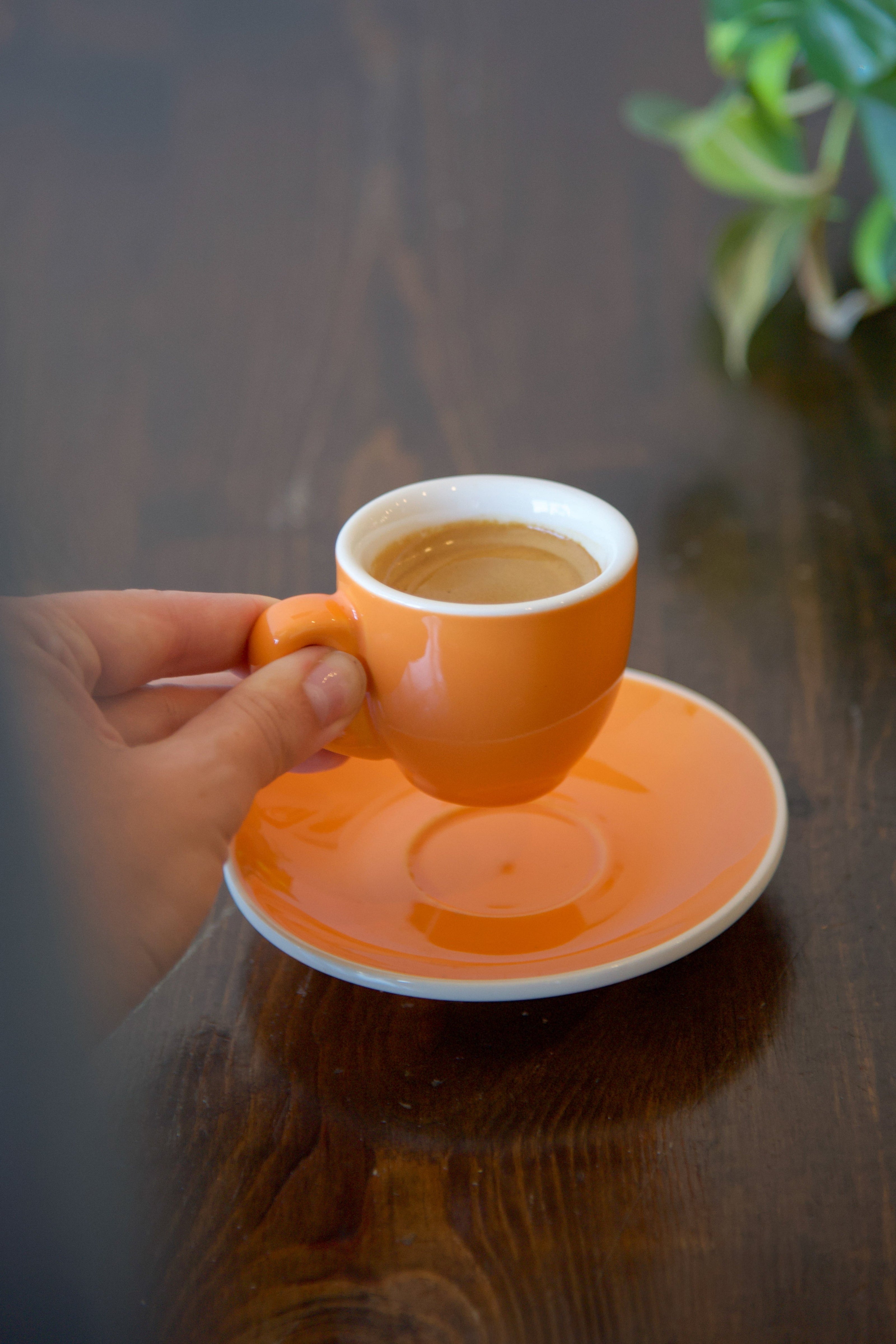 Double shot of espresso in an orange demitasse mug.