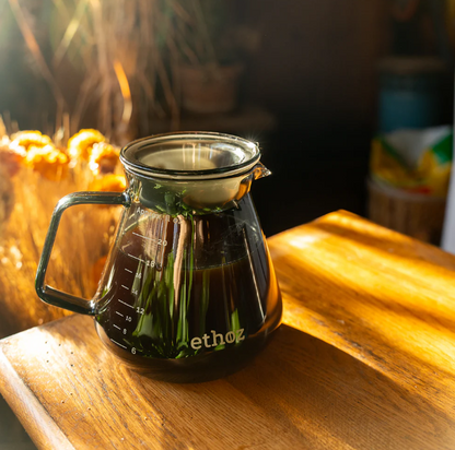 Ethoz glass coffee server on a wooden surface.