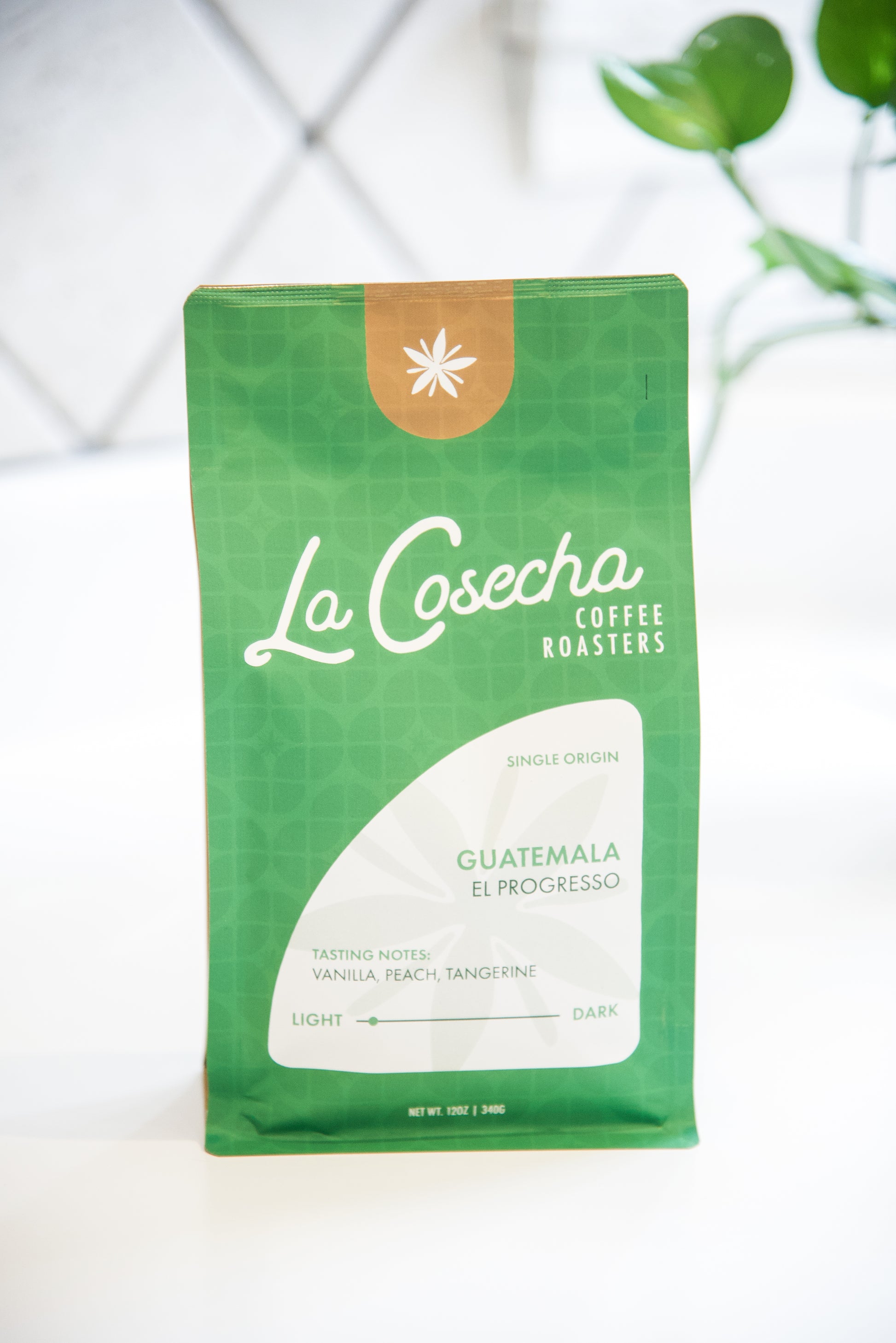 Green coffee bag with 'La Cosecha Coffee Roasters' branding on a white background