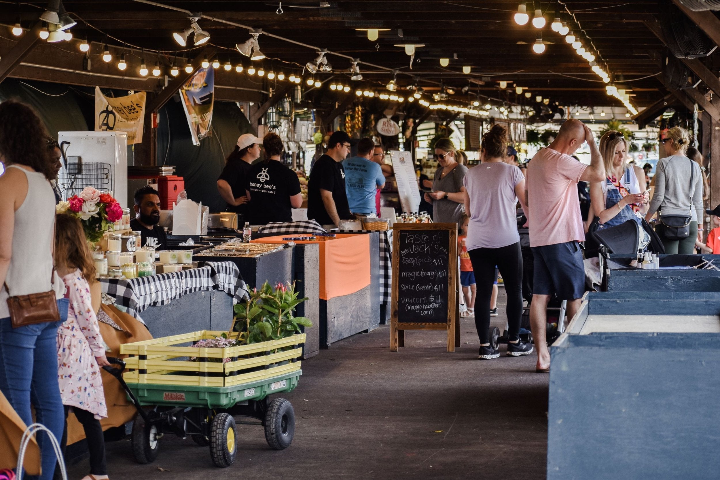 People shopping at an outdoor market under string lights.