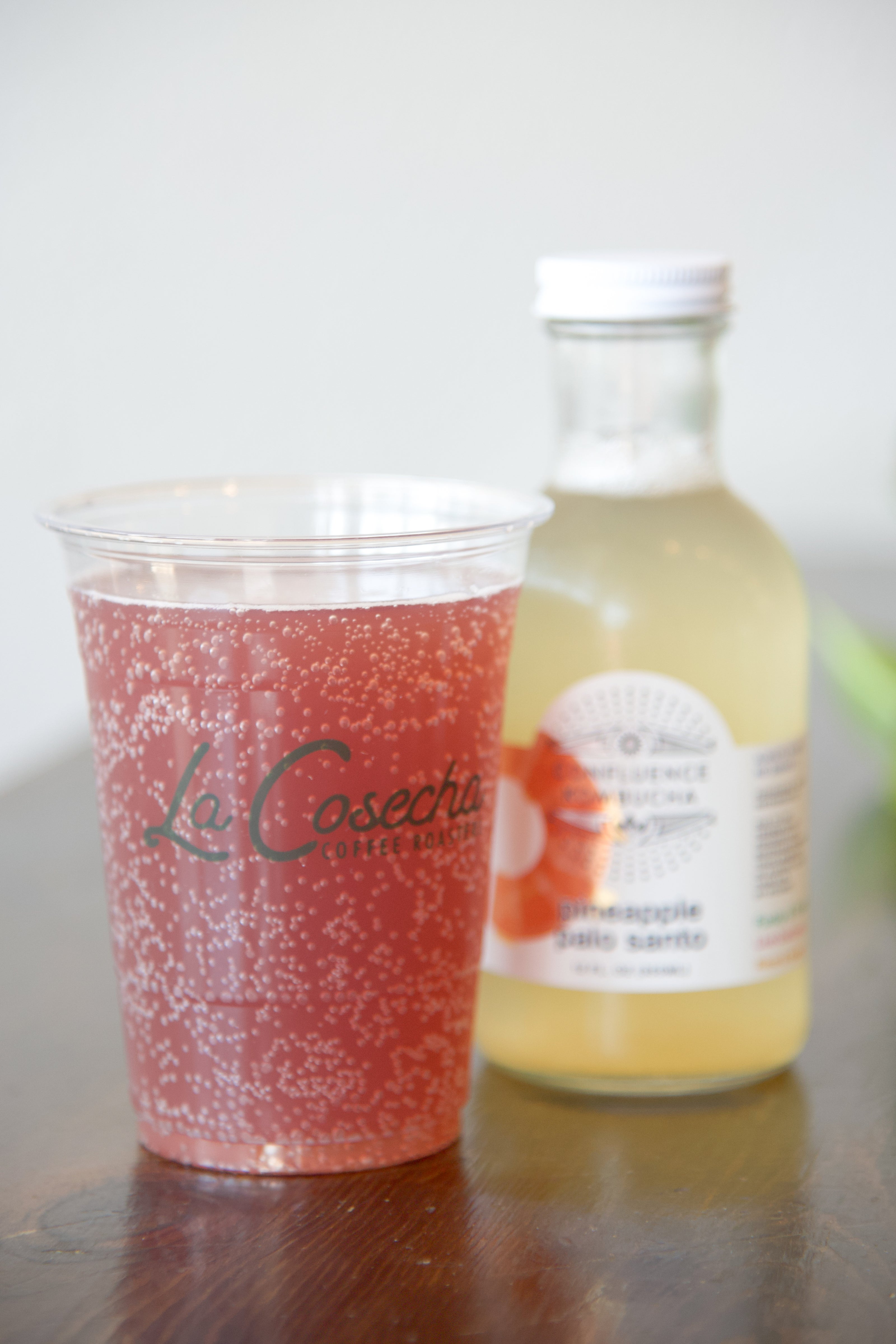 Confluence Kombucha in a bottle or cup to go.