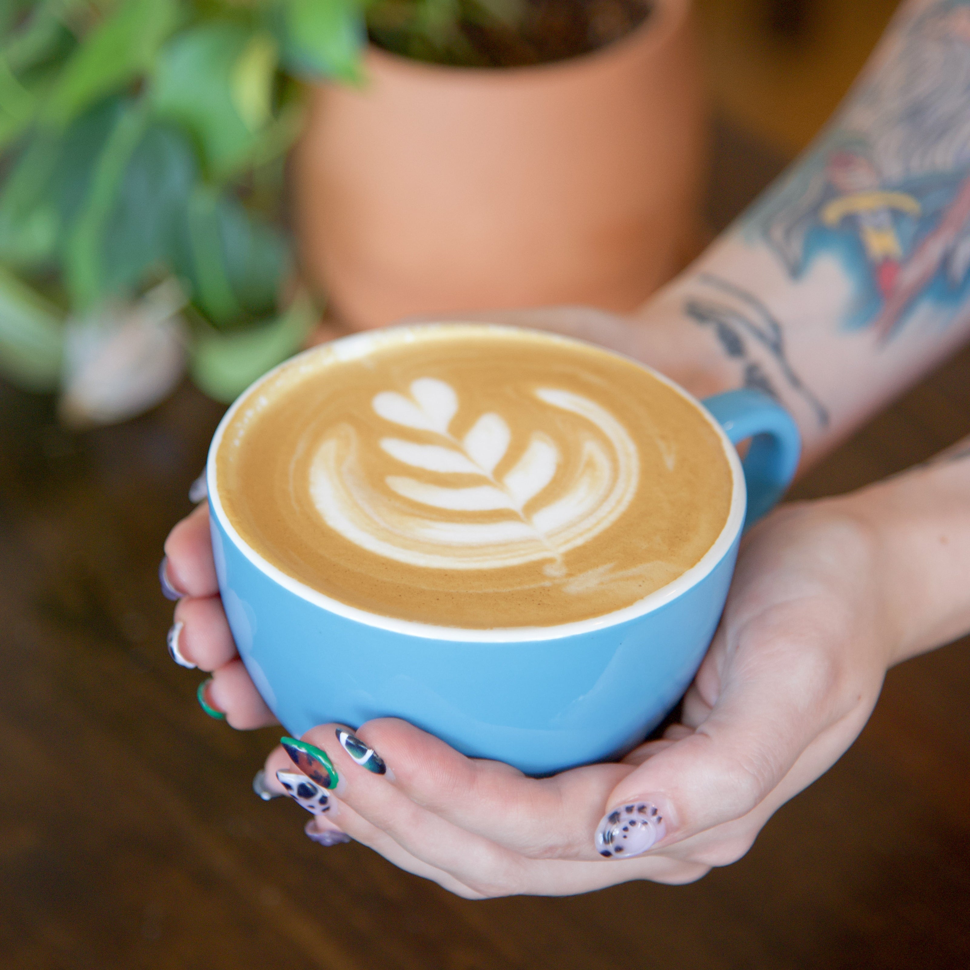 Latte with latte art in blue mug.