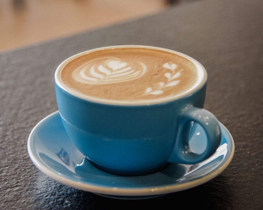 A blue latte mug with latte art.