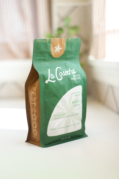 Green coffee bag with La Cosecha branding on a white surface