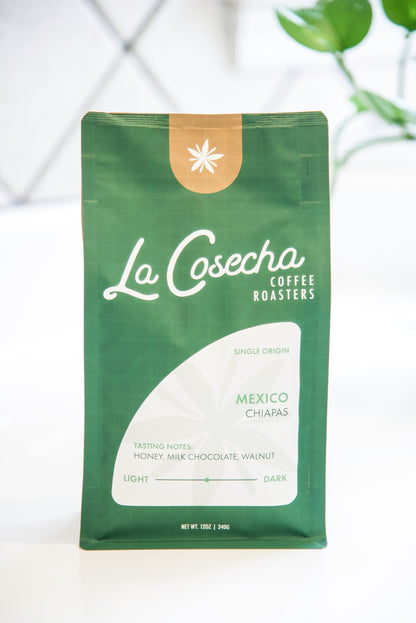 Green coffee bag with 'La Cosecha Coffee Roasters' branding on a white background