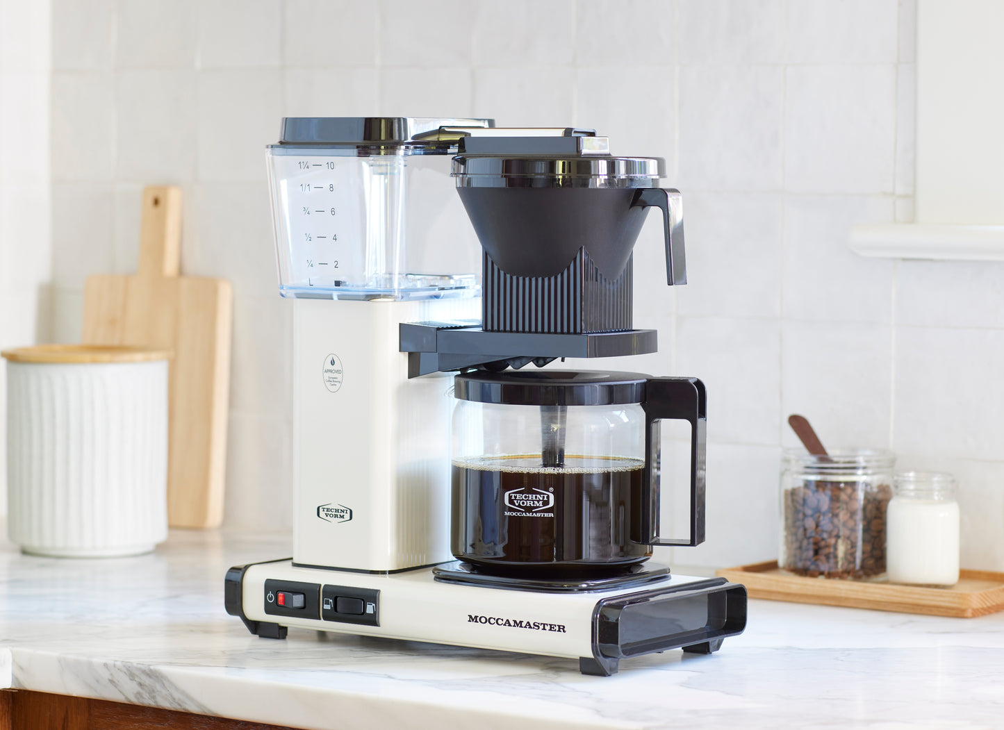 Moccamaster coffee maker on a kitchen counter with a white background