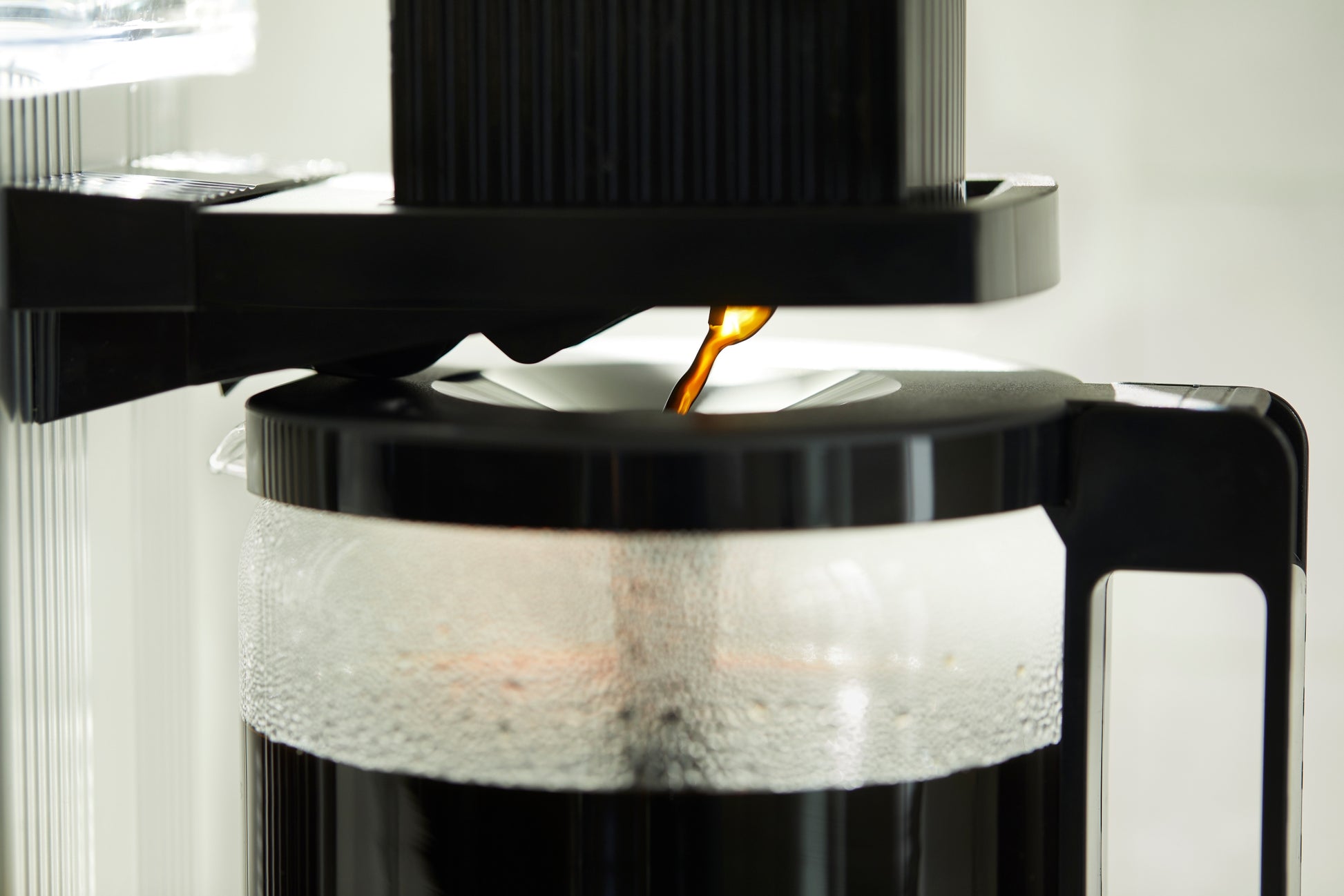 Coffee being poured from a coffee maker into a filter.