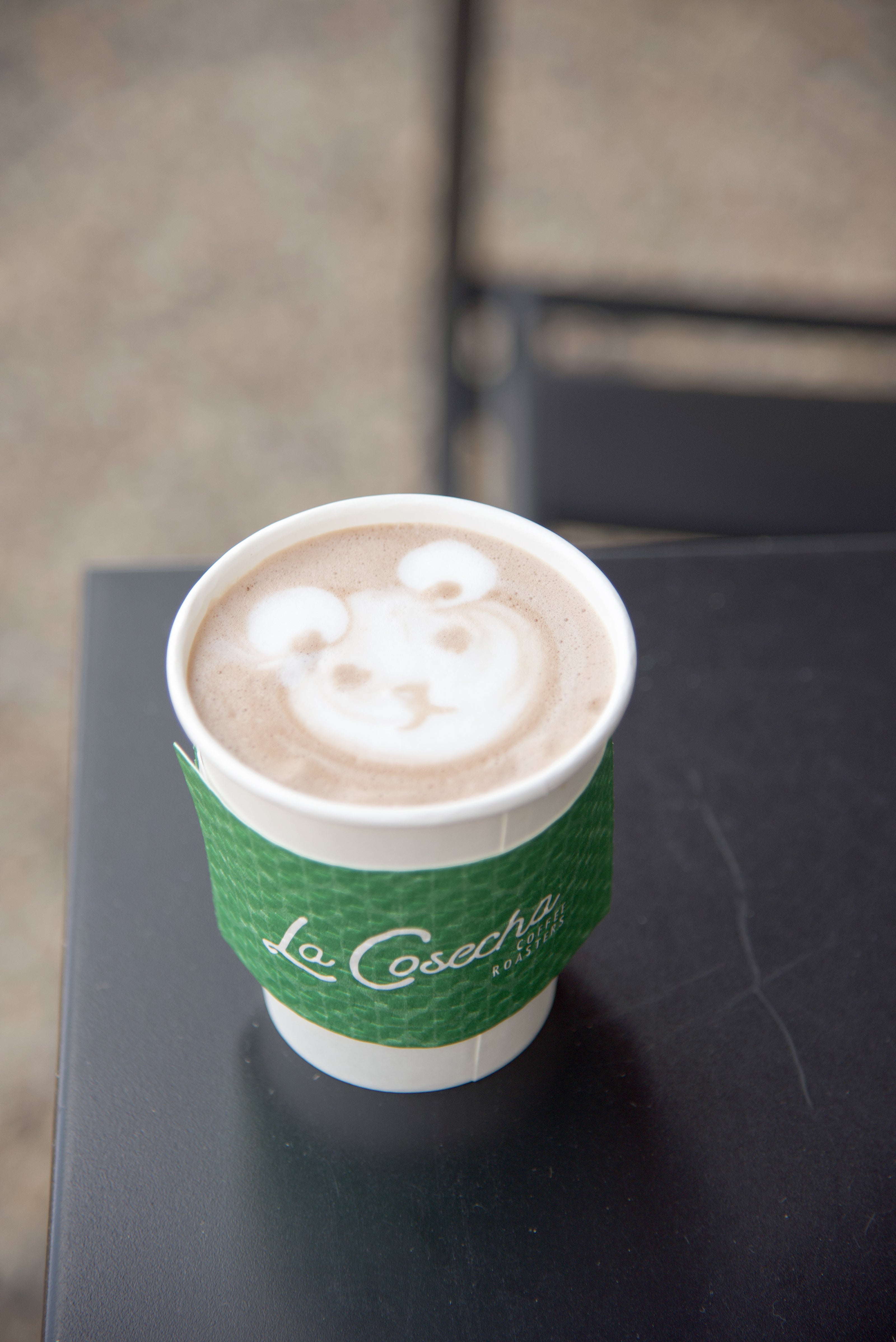 Hot Chocolate with a bear latte art on a black table.
